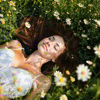Women laying in the flower field with the serene relaxation The sun is shining down on her her eyes are closed and she is embracing the moment