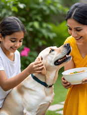 a labrador being fed by a south asian mom and daughter